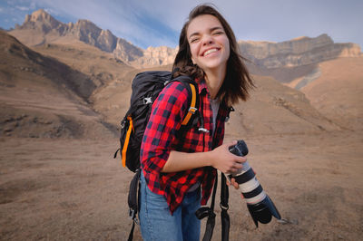 Smiling young woman standing on mountain road