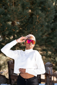 A young african american woman wearing sunglasses having fun in the snow on a winter day