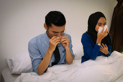 Young couple sitting on bed