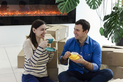 Friends sitting on sofa at home