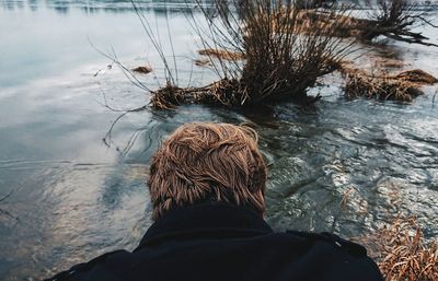 Rear view of man by lake