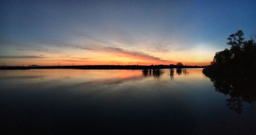 Scenic view of calm lake at sunset