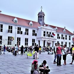 Group of people in building against clear sky