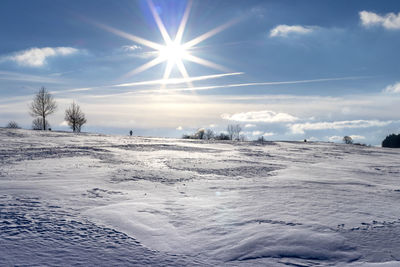 Scenic view of snow covered land against sky