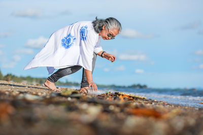 Woman picking up garbage at beach