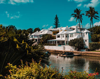 Buildings by lake against sky