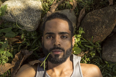 Portrait of young man lying down on land