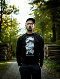 Portrait of young man standing in forest