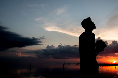 Silhouette man exhaling smoke against sky during sunset