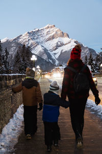Mother and children walking on the sidewalk in banff downtown in winter