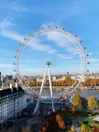 Ferris wheel in city against blue sky