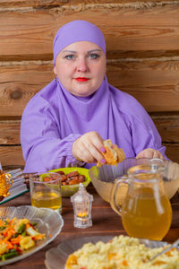 Portrait of woman having food at table