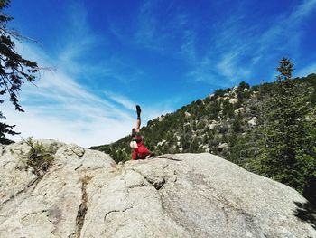 Low angle view of person on mountain against sky