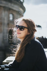 Portrait of young woman in sunglasses against sky