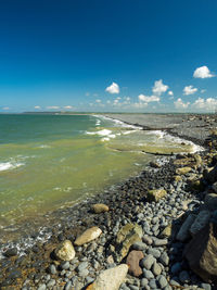 Scenic view of beach against blue sky