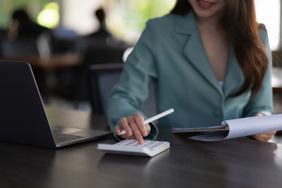 Woman using smart phone while sitting on table