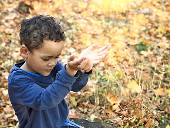 Side view of boy standing in autumn