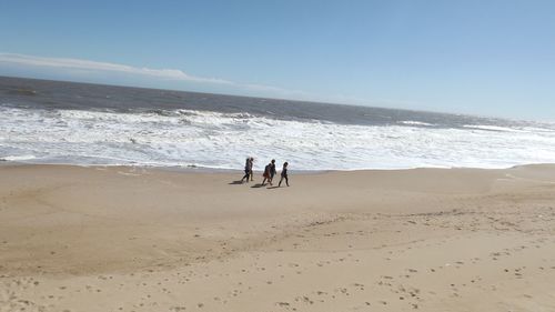 People on beach against sky