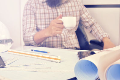 Midsection of woman holding coffee cup