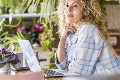 Portrait of woman with mobile phone sitting on table