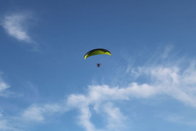 Low angle view of person paragliding against sky