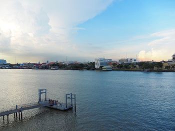 Scenic view of river by buildings against sky