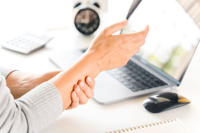 Midsection of woman using laptop on table