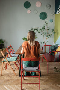 Woman sits back at table with empty chairs next it in modern office