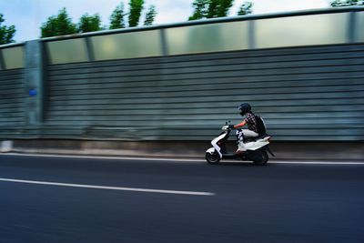 Man riding motor scooter on elevated road