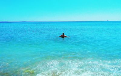 Man surfing in sea against clear sky