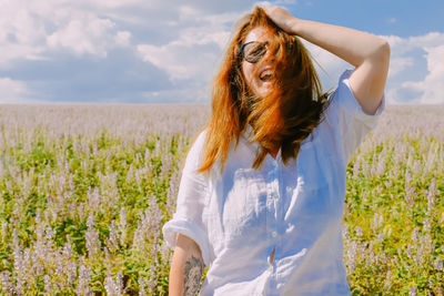 Side view of young woman standing on field