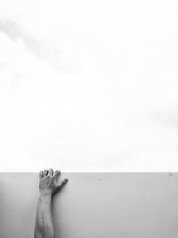 Low section of woman relaxing on land against sky