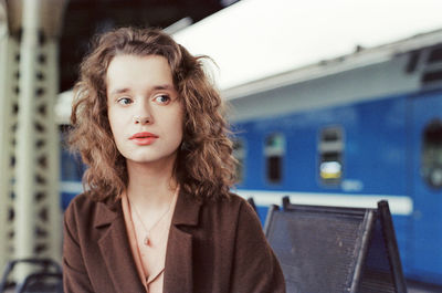 A woman stands near a train at a train station