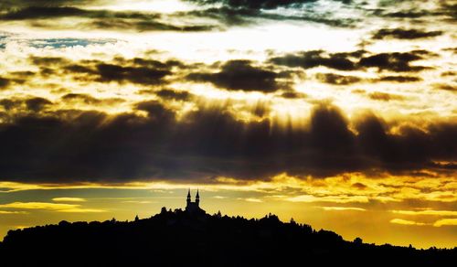 Silhouette of building against cloudy sky