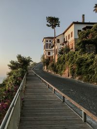 Empty walkway by building against clear sky