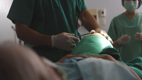 Midsection of doctor examining patient in clinic