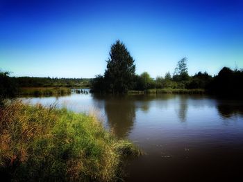 Scenic view of lake against clear blue sky