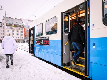 People in cable car on city street during winter