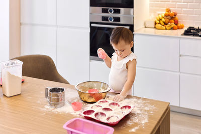 Portrait of young woman preparing food at home