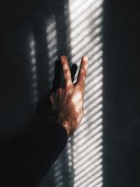 Man hand showing peace sign on wall with shadow