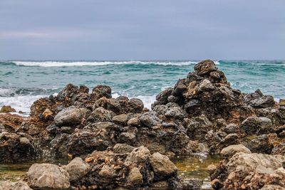 Rocks on beach against sky