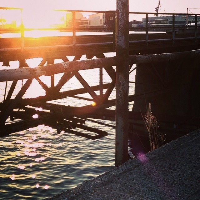 sun, sunlight, water, sunbeam, built structure, railing, sunset, lens flare, architecture, bridge - man made structure, wood - material, nature, no people, pier, reflection, river, outdoors, the way forward, transportation, tranquility