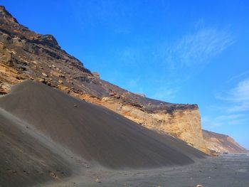 Scenic view of mountains against blue sky