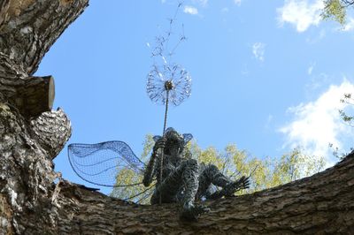 Low angle view of trees against blue sky