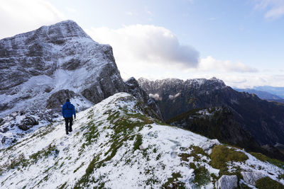 Rear view of people hiking on snowcapped mountain in triglav national park in slovenia