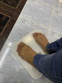 Low section of man standing on tiled floor