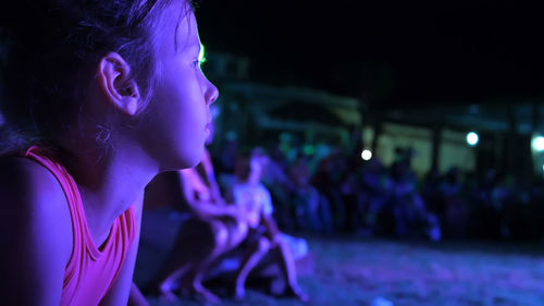 Summer, night, in the rays of soffits, a girl of seven years old, watching the night concert in an