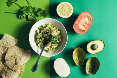 Ingredients on a green background to prepare a guacamole sauce