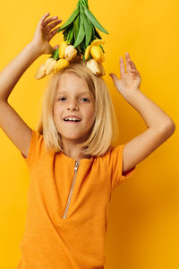 Portrait of young woman against yellow background