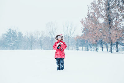 Girl standing on snow covered land